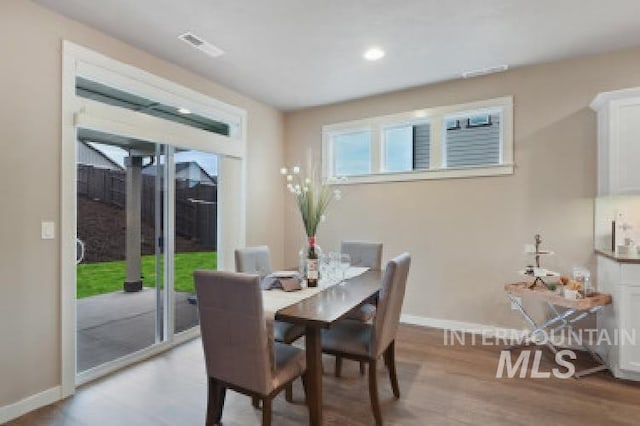 dining area with light wood-type flooring and baseboards