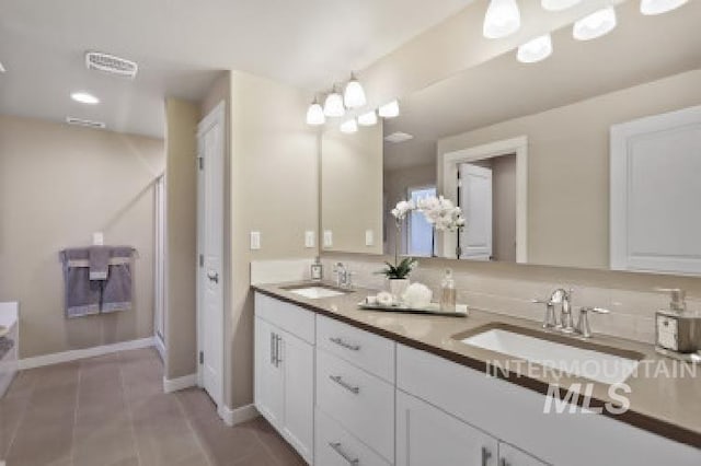 full bath featuring a chandelier, double vanity, a sink, and a shower stall