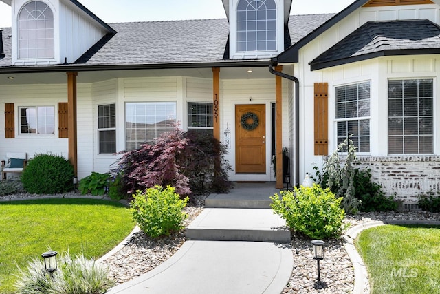 10551 W Deep Canyon Dr, Star, ID 83669 - view of exterior entry featuring board and batten siding, roof with shingles, and a lawn