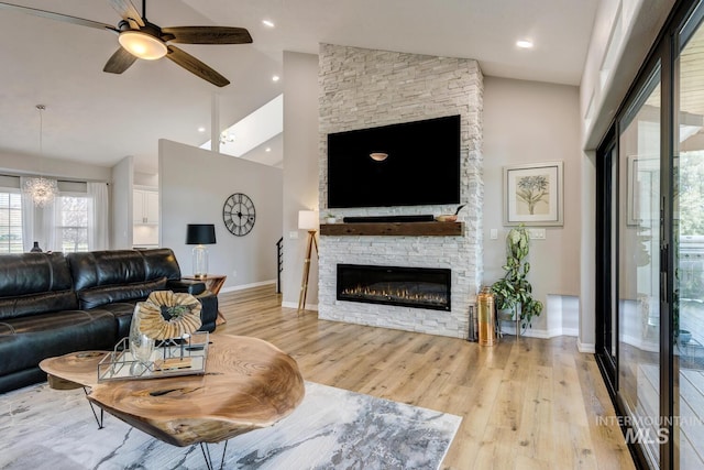 10551 W Deep Canyon Dr, Star, ID 83669 - living area with light wood-style floors, high vaulted ceiling, ceiling fan, and a stone fireplace
