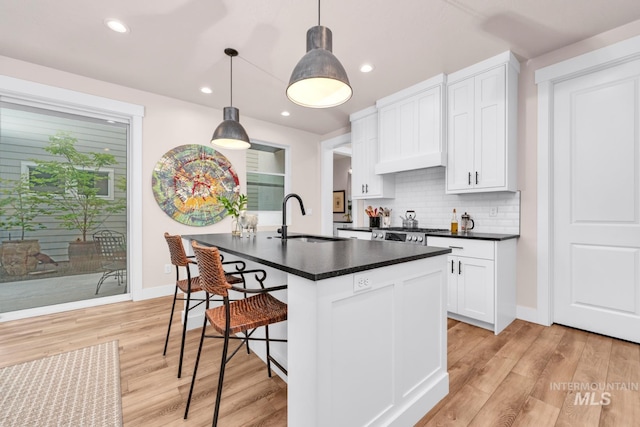 10179 Silversun St, Nampa, ID 83687 - kitchen with a sink, dark countertops, light wood-type flooring, tasteful backsplash, and recessed lighting