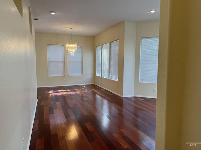 unfurnished room with dark hardwood / wood-style flooring and a notable chandelier