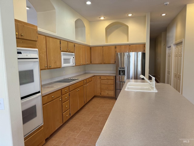 kitchen featuring white appliances, a high ceiling, and sink