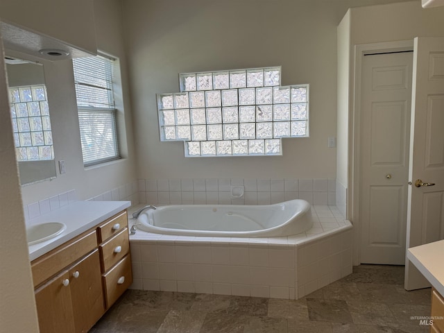 bathroom with a relaxing tiled tub and vanity