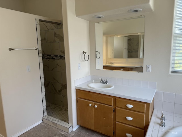 bathroom featuring a tile shower and vanity