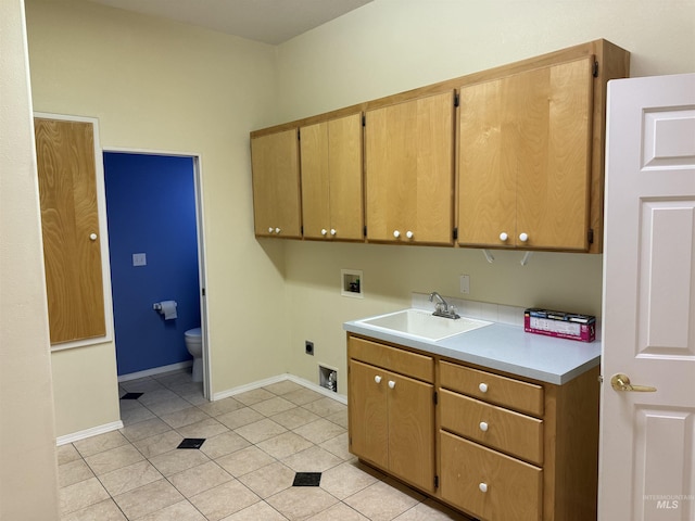 washroom with cabinets, hookup for a washing machine, hookup for an electric dryer, light tile patterned floors, and sink