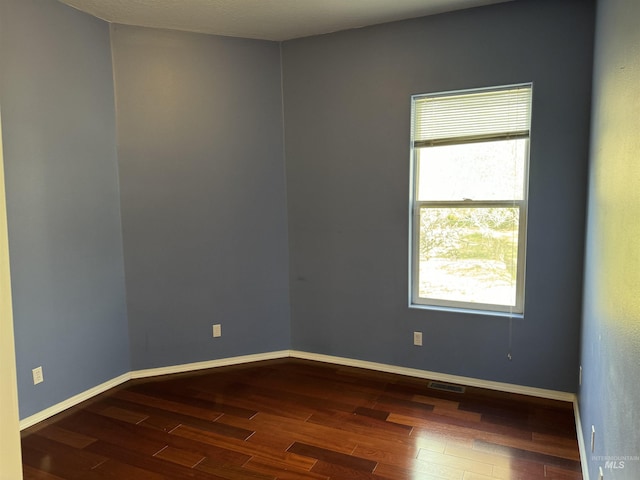 spare room featuring dark wood-type flooring