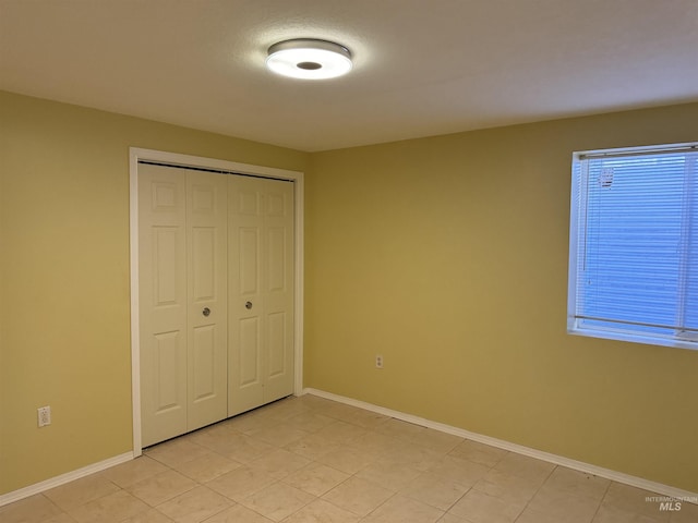 unfurnished bedroom featuring a closet and light tile patterned floors