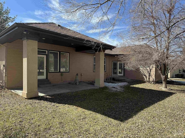 rear view of house featuring a patio area and a lawn