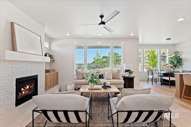 living room with a ceiling fan, recessed lighting, and a brick fireplace