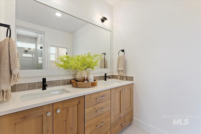bathroom featuring double vanity, tile patterned floors, and a sink
