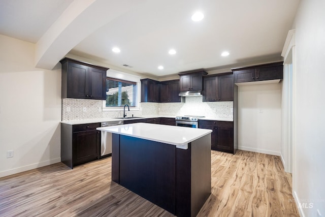 12476 W Kempshire Ct, Star, ID 83669 - kitchen with stainless steel appliances, under cabinet range hood, light wood finished floors, tasteful backsplash, and recessed lighting
