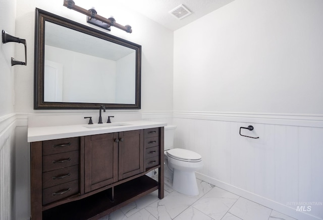12476 W Kempshire Ct, Star, ID 83669 - half bathroom featuring marble look tile flooring, vanity, and wainscoting