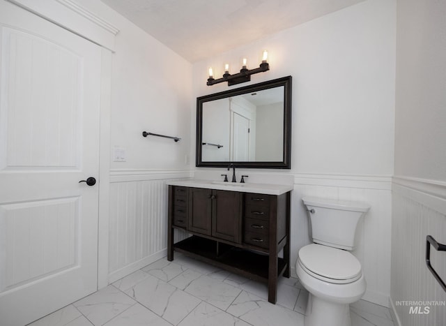 12476 W Kempshire Ct, Star, ID 83669 - bathroom featuring marble finish flooring, wainscoting, and vanity