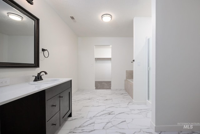 12476 W Kempshire Ct, Star, ID 83669 - bathroom featuring marble finish flooring, vanity, and a bath
