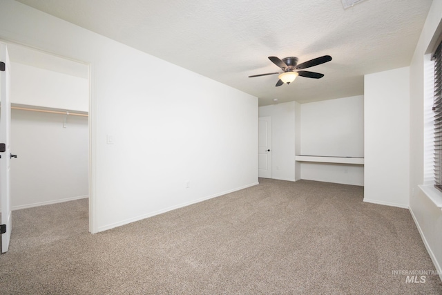 12476 W Kempshire Ct, Star, ID 83669 - unfurnished bedroom featuring carpet, a spacious closet, a closet, a ceiling fan, and a textured ceiling