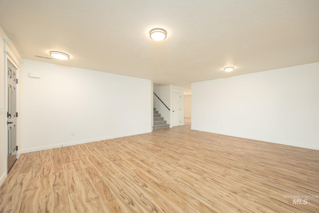 12476 W Kempshire Ct, Star, ID 83669 - finished below grade area featuring stairway, light wood finished floors, and a textured ceiling