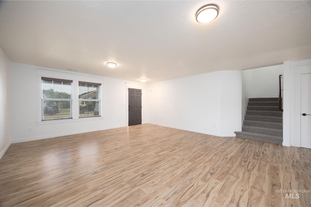 12476 W Kempshire Ct, Star, ID 83669 - unfurnished living room featuring light wood-type flooring and stairway