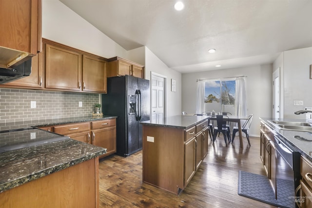 kitchen with a sink, backsplash, a kitchen island, stainless steel dishwasher, and black refrigerator with ice dispenser