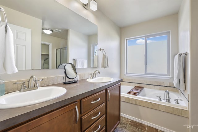 bathroom featuring a sink, a shower with door, a bath, and double vanity