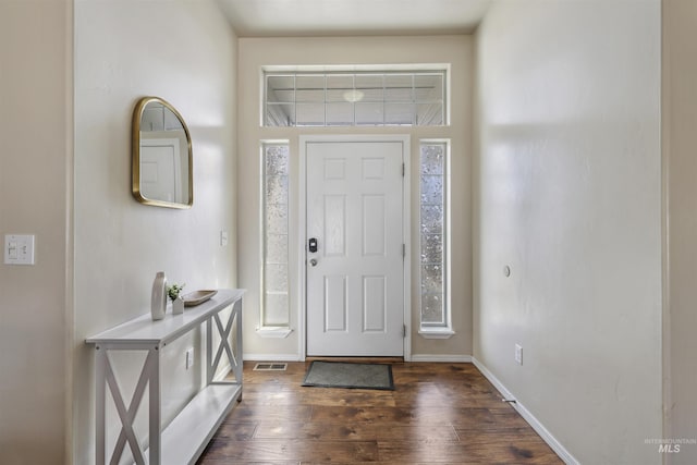 foyer featuring dark wood finished floors, baseboards, and visible vents