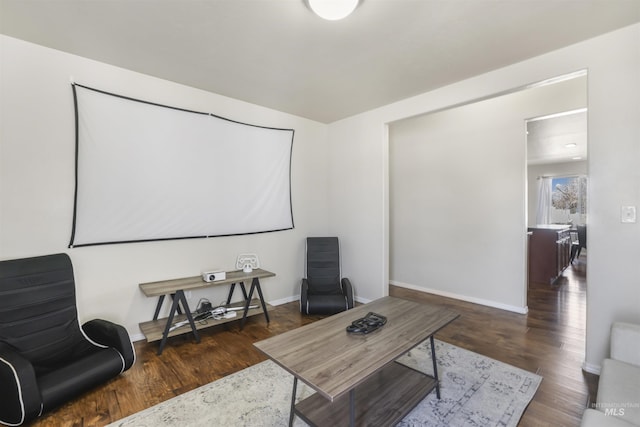 home theater room featuring wood finished floors and baseboards