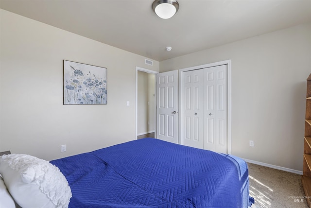 bedroom with a closet, visible vents, baseboards, and carpet floors