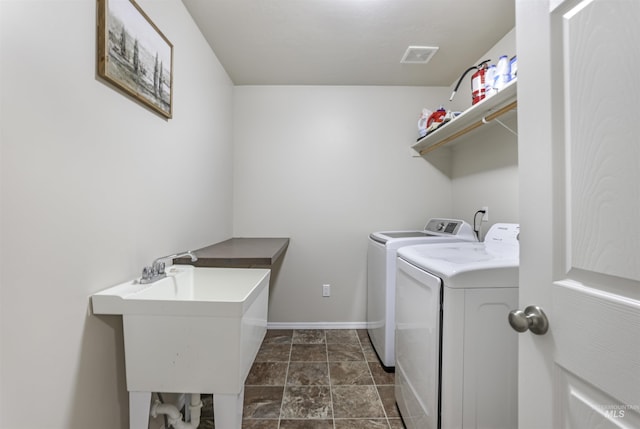 laundry room featuring visible vents, baseboards, laundry area, independent washer and dryer, and a sink