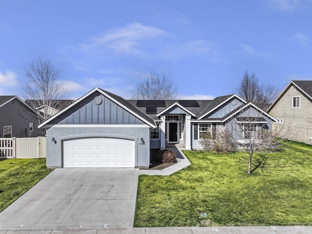 view of front of home featuring driveway, fence, board and batten siding, an attached garage, and a front yard