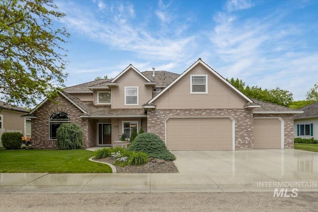 628 E Trinidad Dr, Meridian, ID 83642 - view of front of home with brick siding, driveway, a front lawn, and a garage