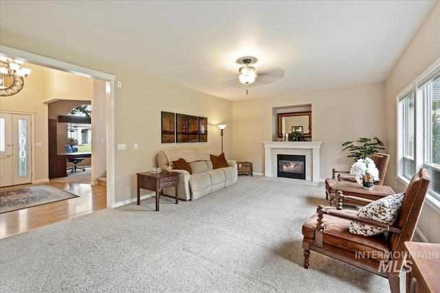 628 E Trinidad Dr, Meridian, ID 83642 - living room with carpet, a ceiling fan, a fireplace with flush hearth, a chandelier, and baseboards
