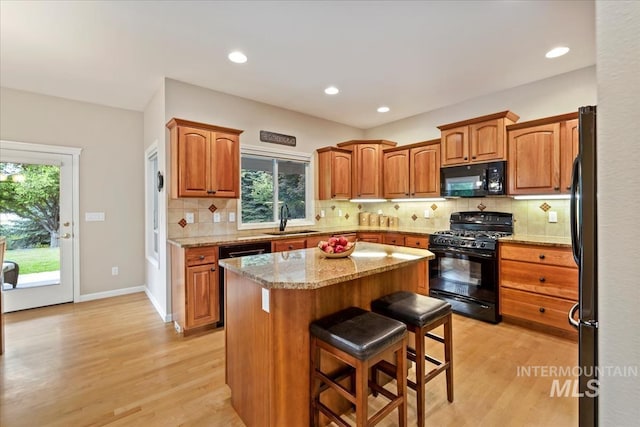 628 E Trinidad Dr, Meridian, ID 83642 - kitchen with black appliances, a sink, light wood finished floors, a center island, and recessed lighting