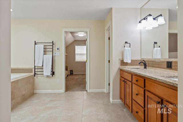 628 E Trinidad Dr, Meridian, ID 83642 - bathroom featuring double vanity, tile patterned floors, decorative backsplash, radiator heating unit, and tiled tub