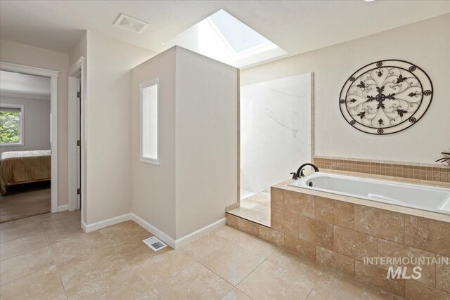 628 E Trinidad Dr, Meridian, ID 83642 - ensuite bathroom with a skylight, a bath, tile patterned flooring, and baseboards