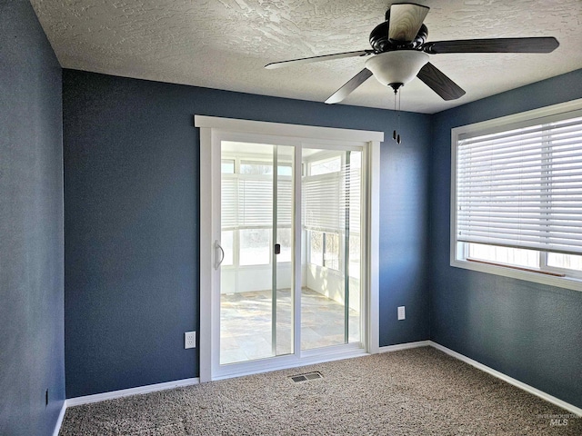 empty room with ceiling fan, carpet floors, and a textured ceiling