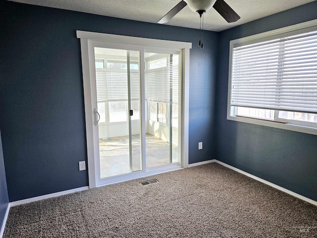 carpeted spare room featuring ceiling fan