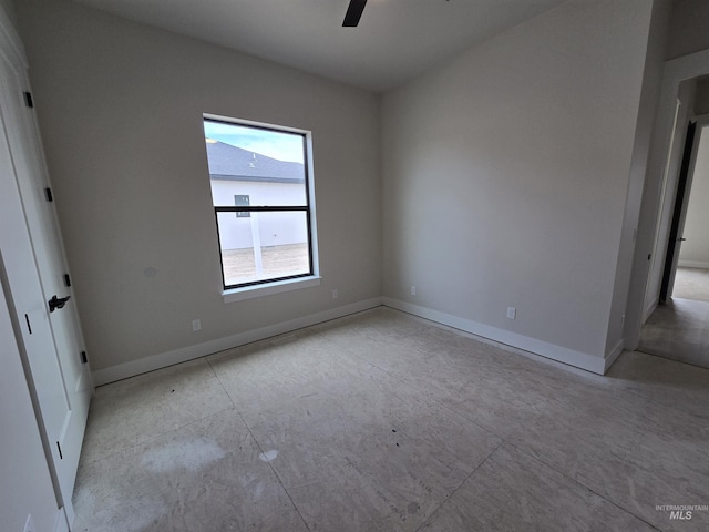spare room featuring baseboards and ceiling fan