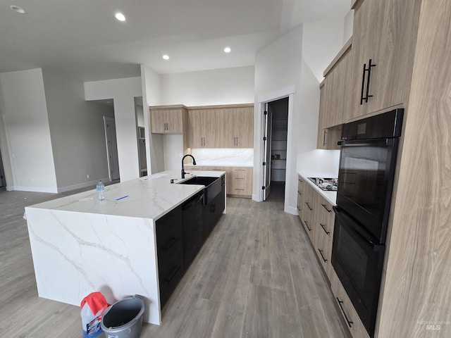 kitchen featuring modern cabinets, a sink, a spacious island, light wood-type flooring, and recessed lighting