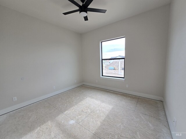 unfurnished room with a ceiling fan and baseboards