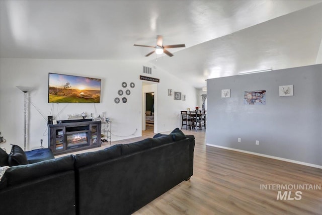 197 Cedarpark Cir, Twin Falls, ID 83301 - living area featuring vaulted ceiling, ceiling fan, wood finished floors, a glass covered fireplace, and baseboards