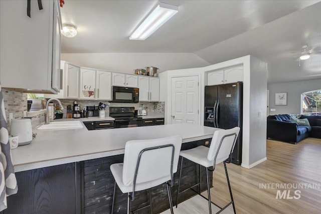 197 Cedarpark Cir, Twin Falls, ID 83301 - kitchen featuring black appliances, a sink, a peninsula, backsplash, and light countertops