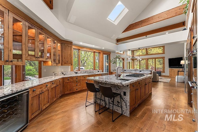 1040 W Bogus Vw, Eagle, ID 83616 - kitchen featuring light stone counters, brown cabinets, a sink, and wine cooler