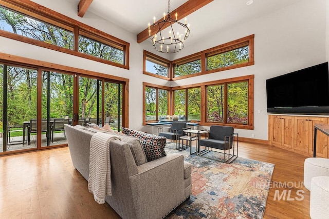 1040 W Bogus Vw, Eagle, ID 83616 - living area featuring wood finished floors, a chandelier, beamed ceiling, a high ceiling, and baseboards