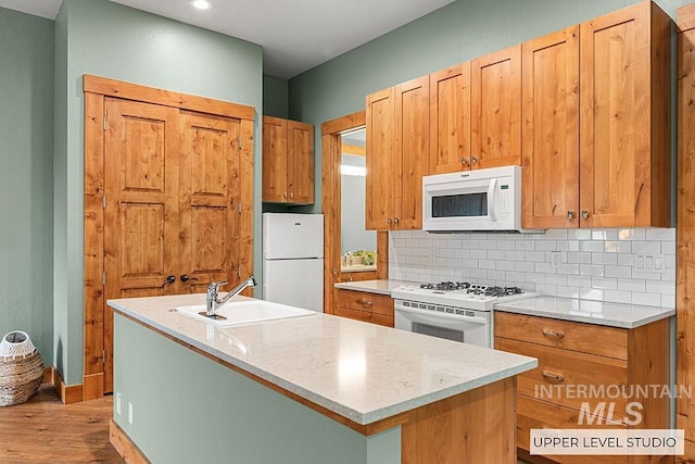 1040 W Bogus Vw, Eagle, ID 83616 - kitchen featuring white appliances, light wood finished floors, a sink, backsplash, and light countertops