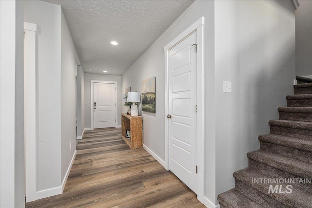 4849 N Willowside Ave, Meridian, ID 83646 - hallway featuring wood finished floors, recessed lighting, stairway, baseboards, and a textured ceiling