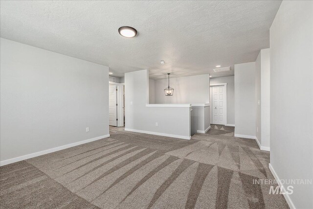 4849 N Willowside Ave, Meridian, ID 83646 - unfurnished living room featuring carpet, a textured ceiling, and baseboards