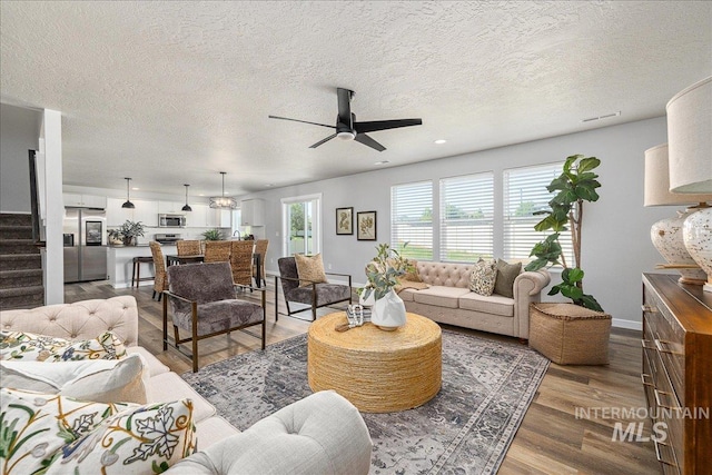 4849 N Willowside Ave, Meridian, ID 83646 - living area with ceiling fan, stairs, wood finished floors, a textured ceiling, and baseboards