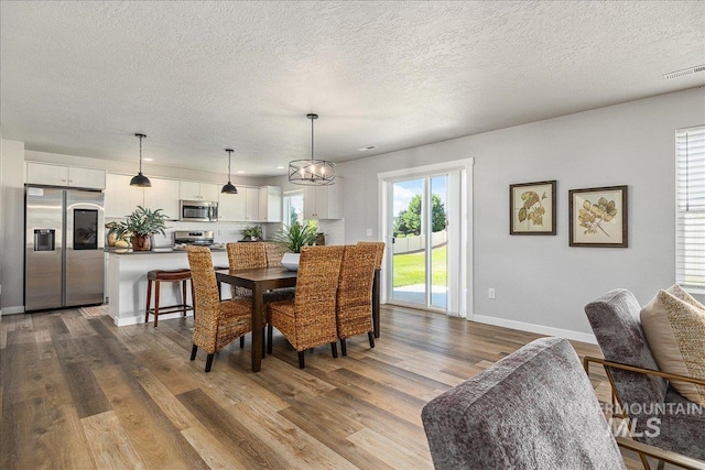 4849 N Willowside Ave, Meridian, ID 83646 - dining area featuring dark wood-style floors, baseboards, a textured ceiling, and recessed lighting