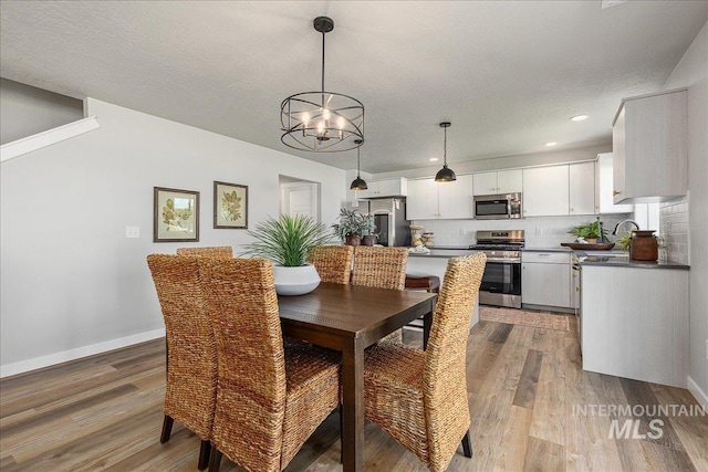 4849 N Willowside Ave, Meridian, ID 83646 - dining area featuring a chandelier, light wood-style floors, baseboards, and recessed lighting