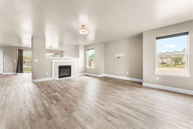 5291 N Midnight Haze Way, Meridian, ID 83646 - unfurnished living room featuring light wood finished floors and a tiled fireplace